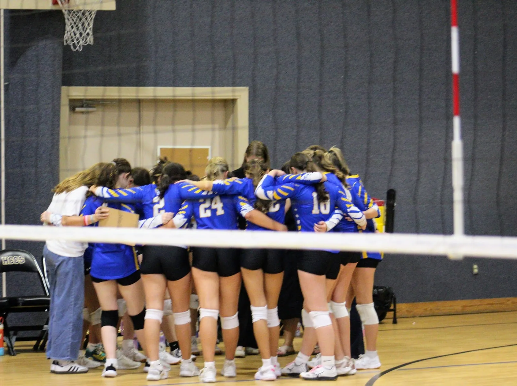 The Hill Country Christian School volleyball team in a huddle before a match